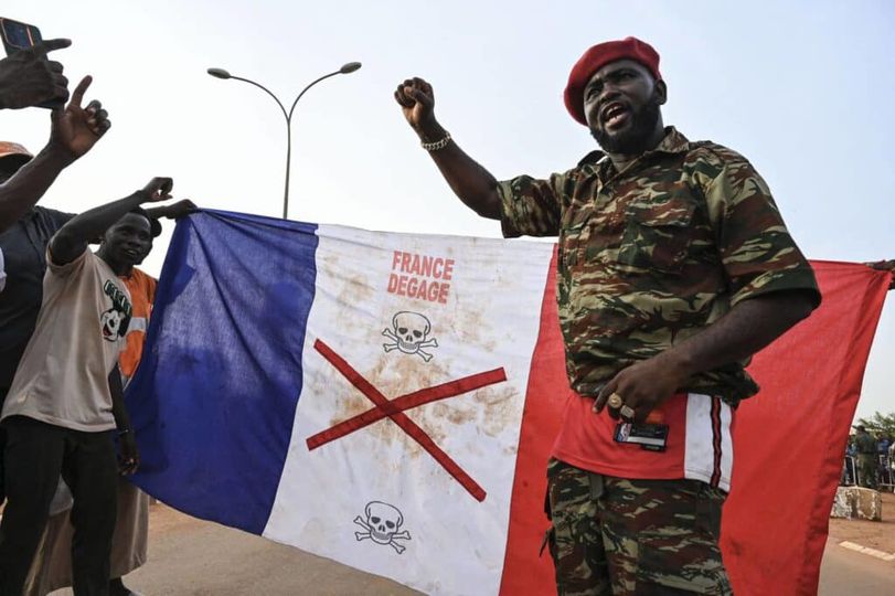 Supporters of Niger's National Council of Safeguard of the Homeland (CNSP) display a French national flag with a x-mark on during a protest outside Niger and French airbase in Niamey on September 1, 2023 to demand the departure of the French army from Niger. (Photo by AFP)